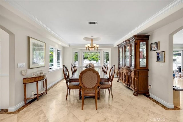 dining room with visible vents, ornamental molding, baseboards, a chandelier, and arched walkways
