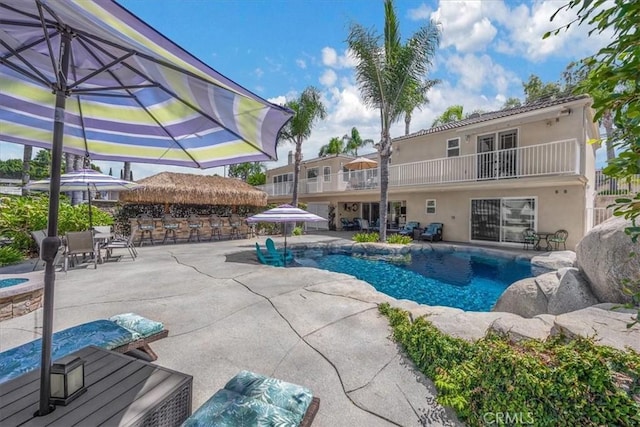 pool with a hot tub, a patio area, and outdoor dry bar