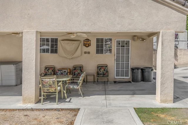 view of patio with outdoor dining area and a ceiling fan