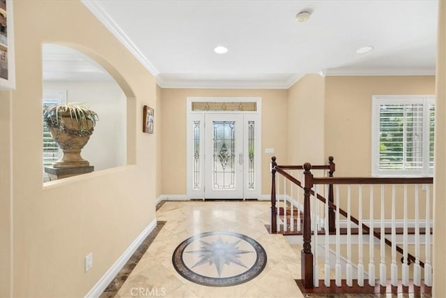 entryway with crown molding, baseboards, recessed lighting, and arched walkways