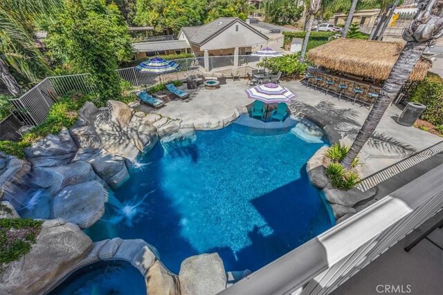view of pool featuring an outdoor hot tub, a patio area, outdoor dry bar, fence, and a fenced in pool