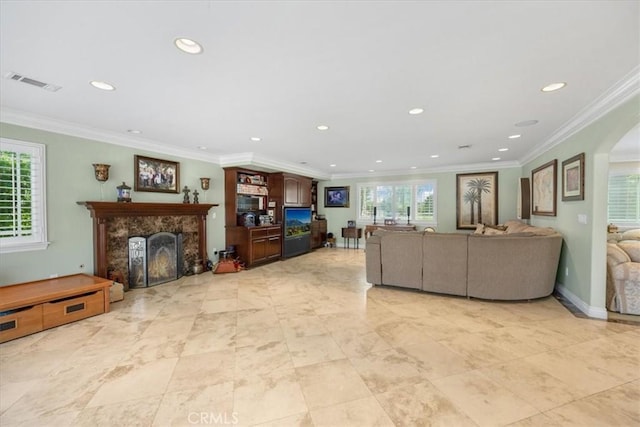 living area featuring visible vents, ornamental molding, recessed lighting, and a fireplace
