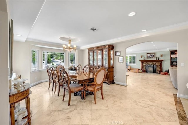 dining space featuring crown molding, baseboards, plenty of natural light, and a notable chandelier
