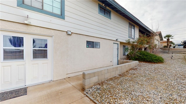 view of property exterior with stucco siding and fence