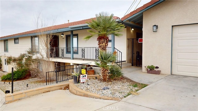 entrance to property featuring stucco siding, a porch, and a garage