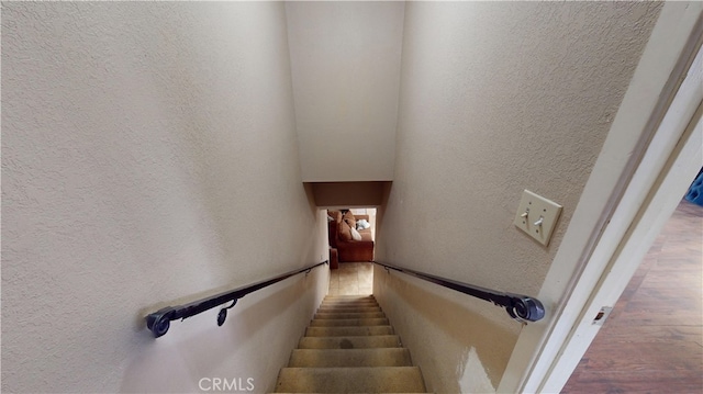 stairway featuring a textured wall