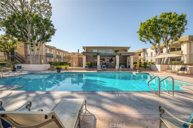 pool featuring a patio area, fence, and a residential view