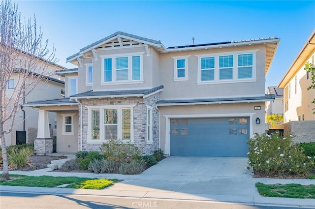 craftsman-style house featuring a garage, stone siding, concrete driveway, and stucco siding