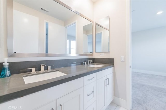 full bathroom with visible vents, a sink, baseboards, and double vanity