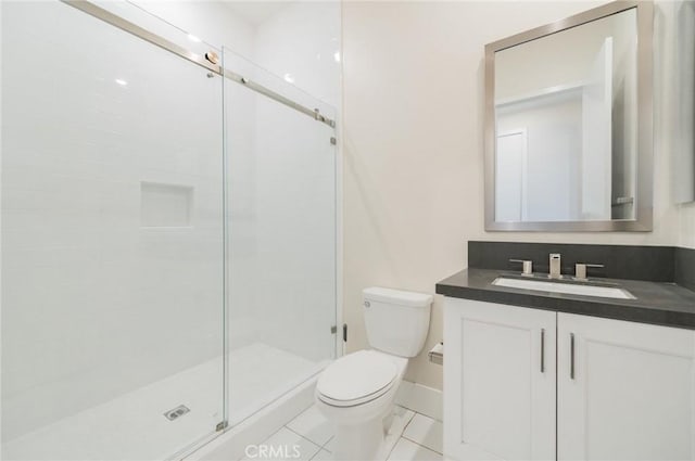 bathroom with toilet, a shower stall, baseboards, and vanity