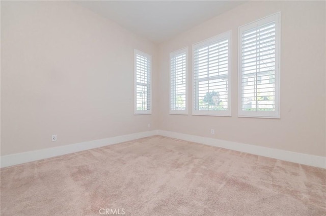 carpeted empty room with baseboards