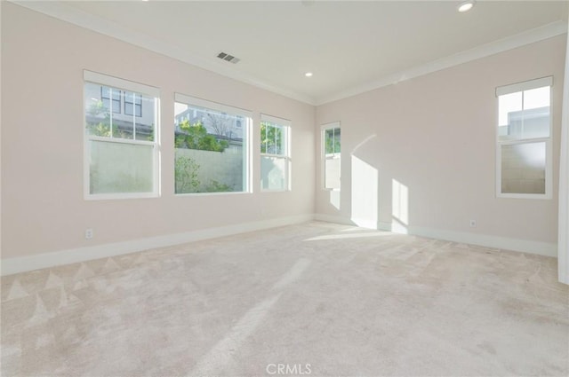 carpeted spare room with ornamental molding, visible vents, and baseboards