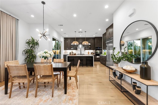 dining area with a wealth of natural light, recessed lighting, a notable chandelier, and light wood finished floors