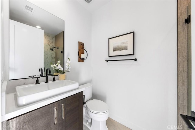 full bathroom featuring visible vents, baseboards, toilet, vanity, and a shower stall