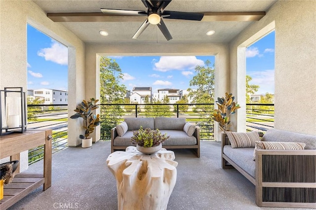 sunroom with beamed ceiling and a ceiling fan