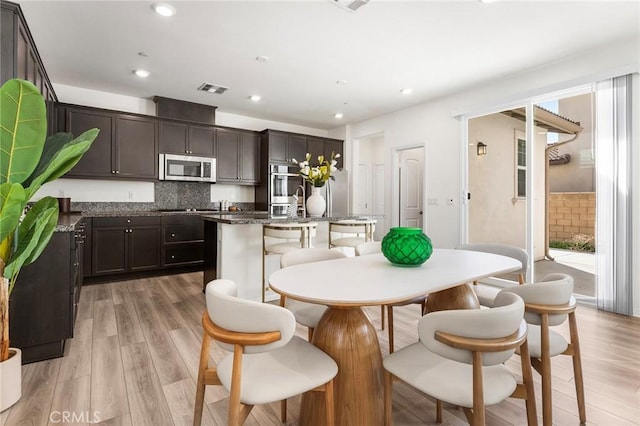 dining room with light wood-type flooring, visible vents, and recessed lighting