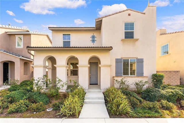 mediterranean / spanish house with a tiled roof and stucco siding