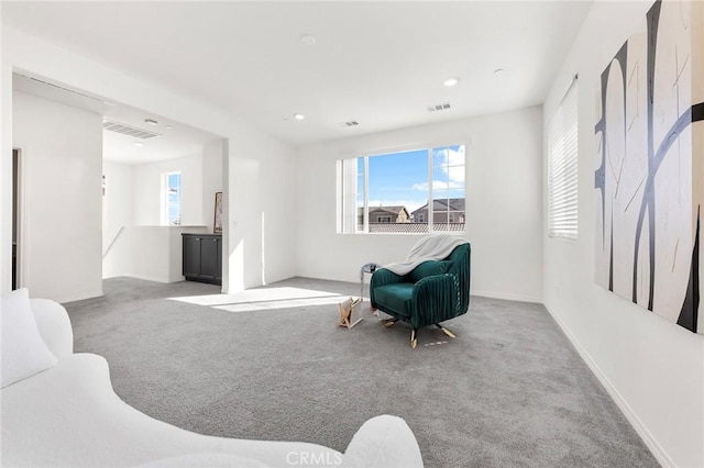 sitting room featuring carpet floors, visible vents, and baseboards