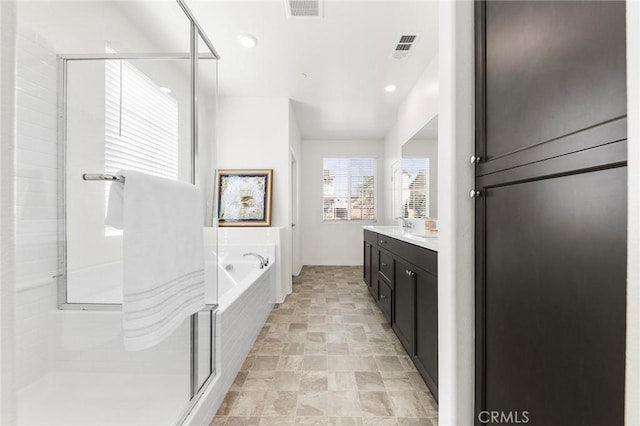 full bathroom with visible vents, a stall shower, a garden tub, and vanity