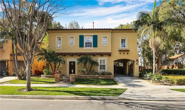 mediterranean / spanish home with stucco siding, driveway, and a tiled roof