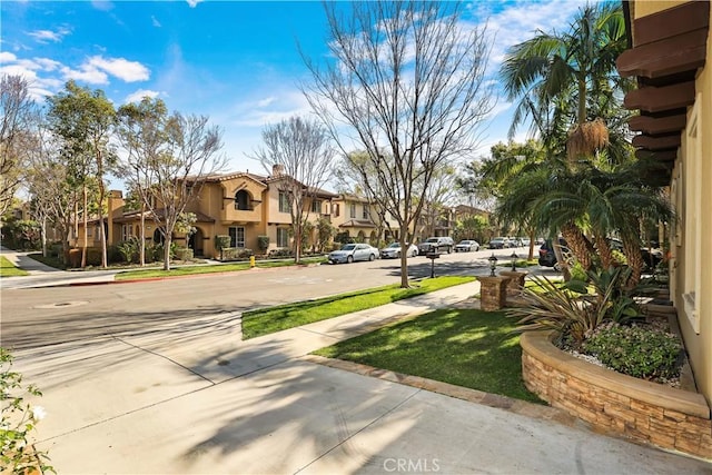 view of home's community with a residential view and a lawn