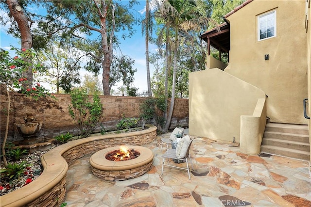 view of patio with an outdoor fire pit and a fenced backyard
