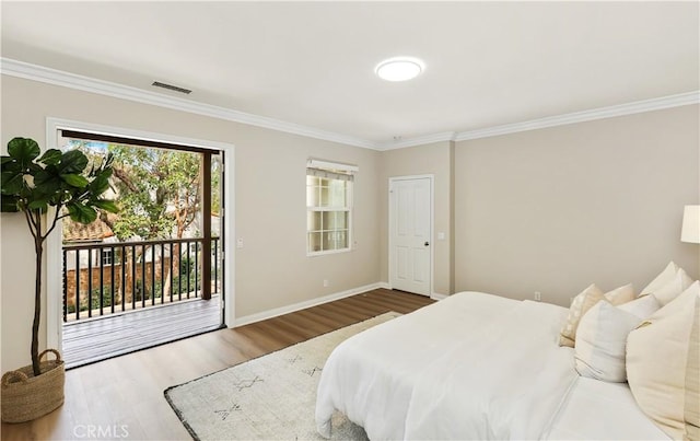 bedroom with access to outside, wood finished floors, visible vents, and crown molding