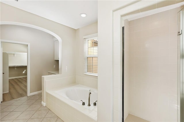 bathroom featuring a stall shower, tile patterned flooring, and a bath