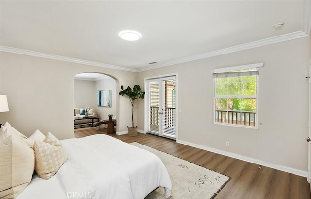 bedroom featuring access to exterior, arched walkways, ornamental molding, wood finished floors, and baseboards