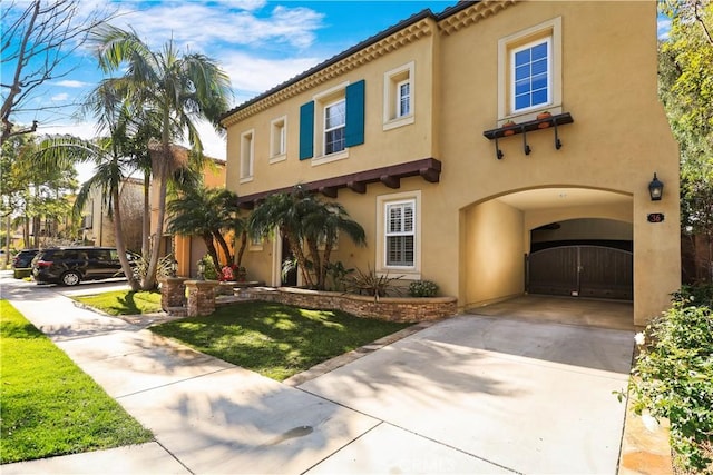 mediterranean / spanish house with stucco siding, driveway, an attached garage, and a front yard
