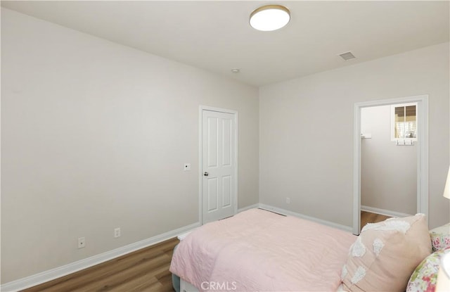 bedroom featuring baseboards and wood finished floors