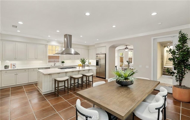 dining area with arched walkways, crown molding, recessed lighting, visible vents, and tile patterned floors