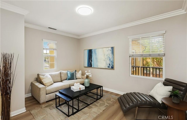 living room with visible vents, crown molding, baseboards, and wood finished floors