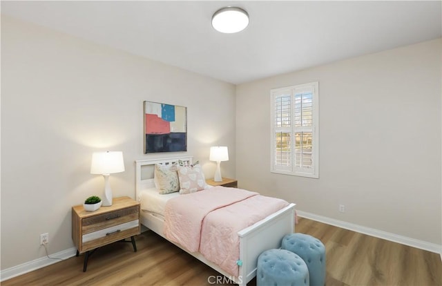 bedroom with baseboards and wood finished floors