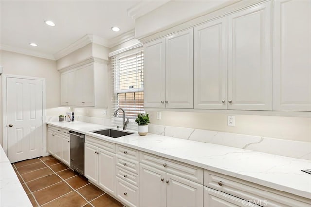 kitchen with a sink, stainless steel dishwasher, crown molding, white cabinetry, and dark tile patterned flooring