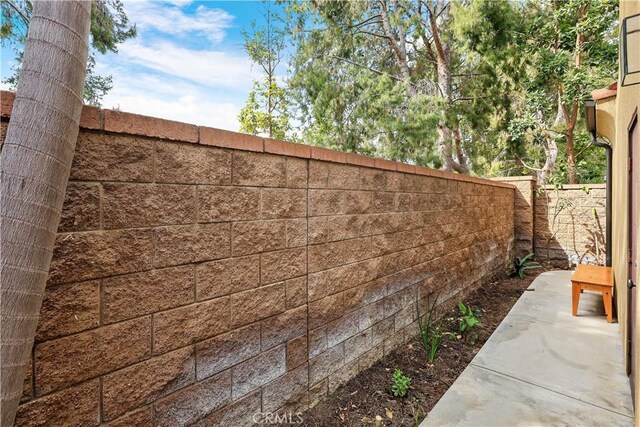 view of side of home featuring a fenced backyard and a patio area