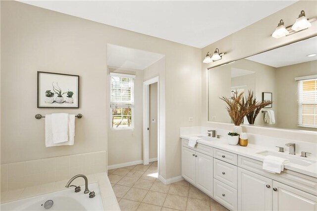 full bathroom featuring a sink, double vanity, tile patterned flooring, and a bath