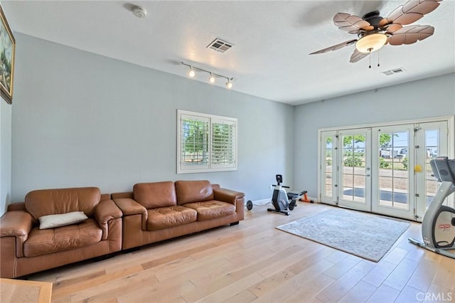 living room featuring ceiling fan, french doors, visible vents, and light wood-style floors