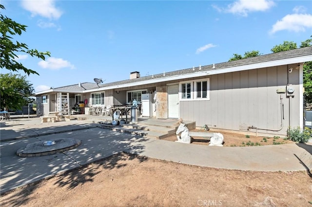 rear view of house featuring a patio area and a chimney