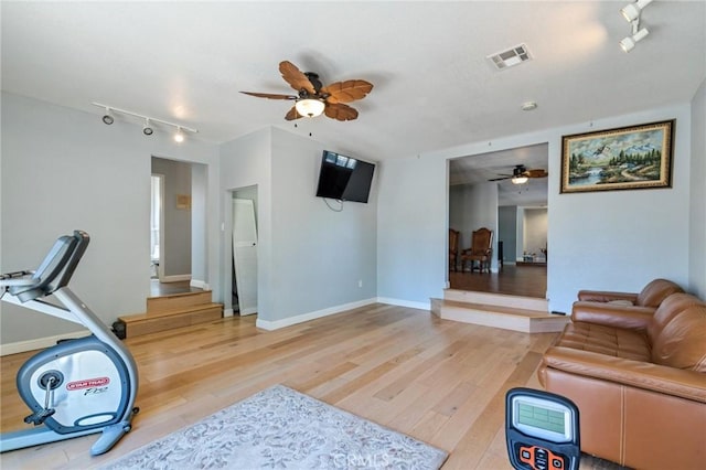 exercise room with light wood finished floors, visible vents, and a ceiling fan