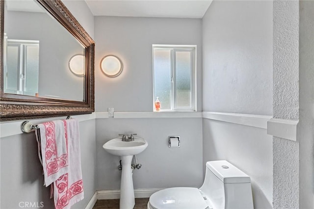 bathroom featuring baseboards and toilet