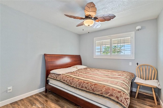 bedroom with a ceiling fan, baseboards, and wood finished floors