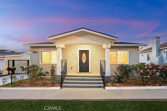 bungalow-style home with stucco siding