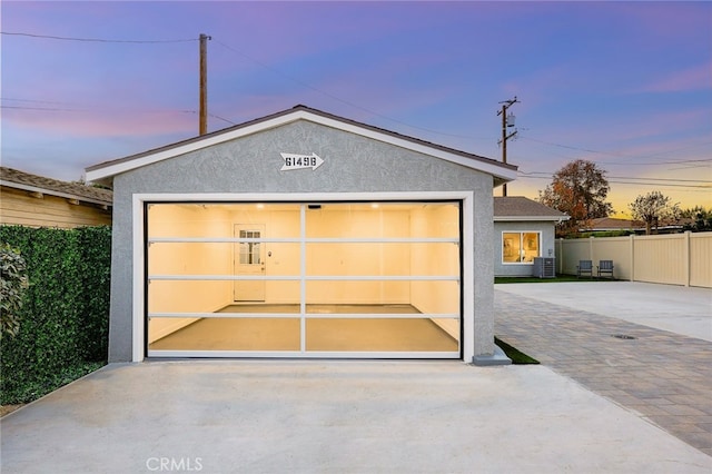 detached garage featuring fence and central AC unit