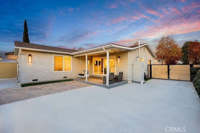 back of house with crawl space, a patio area, fence, and stucco siding