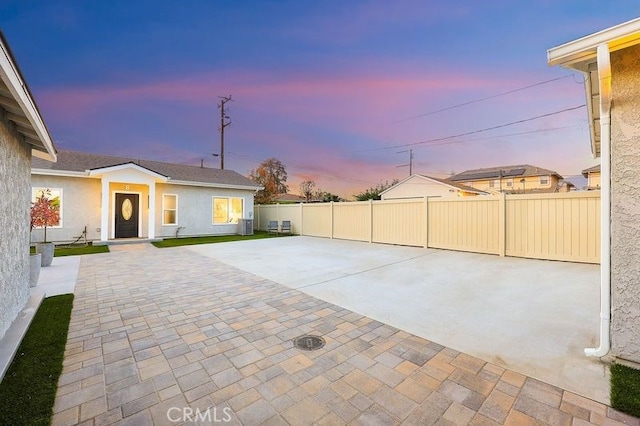 patio terrace at dusk with cooling unit and fence