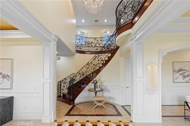 stairway featuring ornate columns, a decorative wall, and crown molding