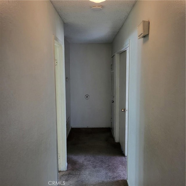 corridor featuring carpet flooring and a textured ceiling