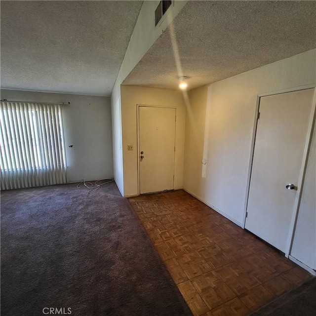 carpeted entrance foyer featuring visible vents and a textured ceiling