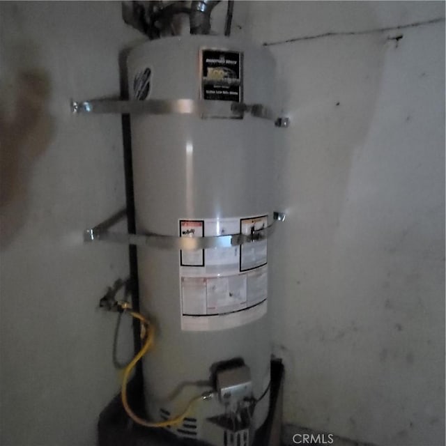 utility room featuring strapped water heater